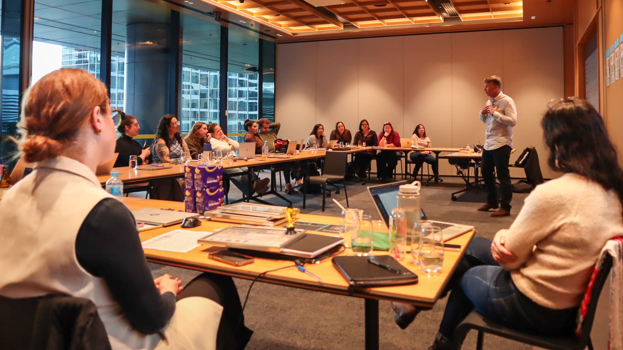 Liam presenting to a full room during a live simulation debrief